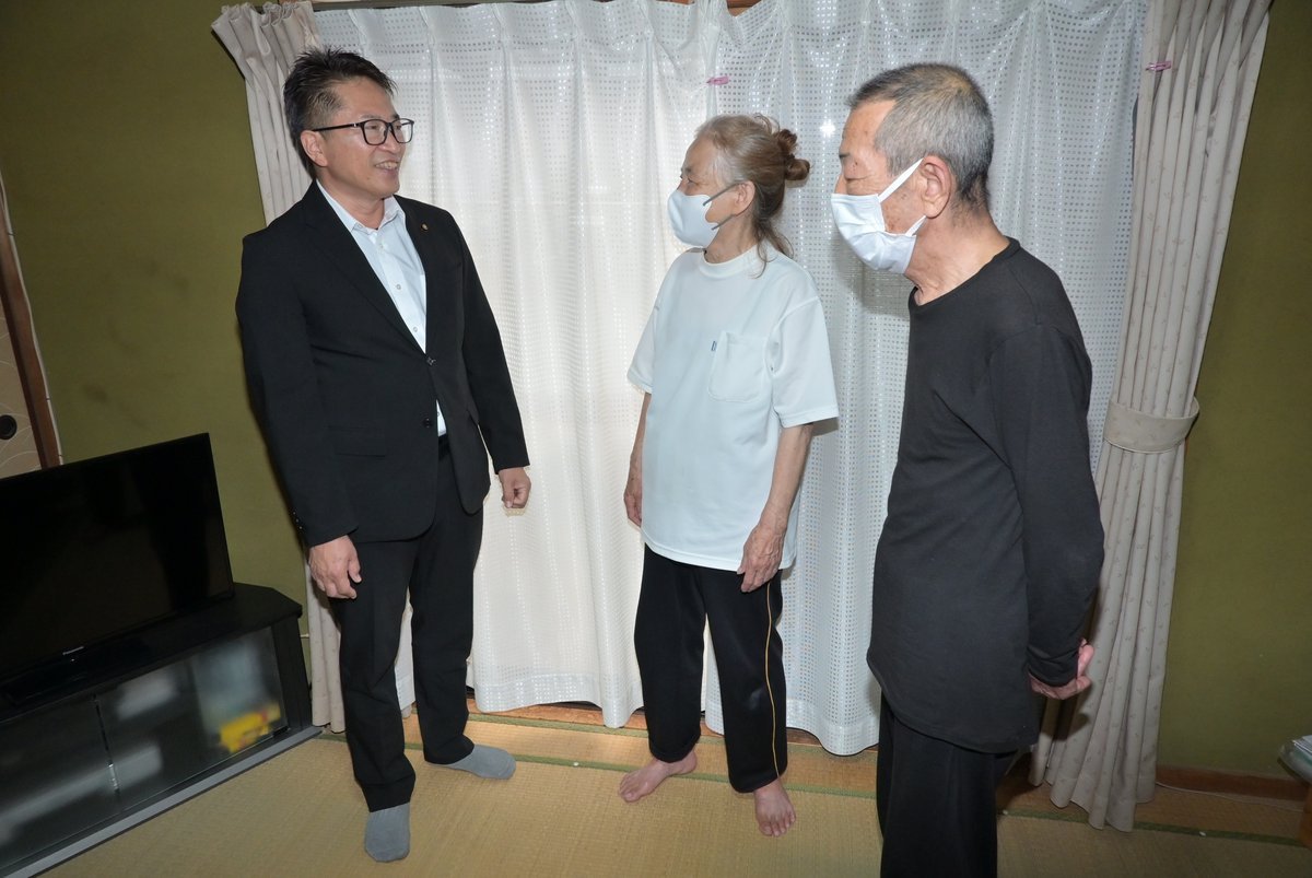 配布された商品券について住民から話を聞く徳村登志郎議員